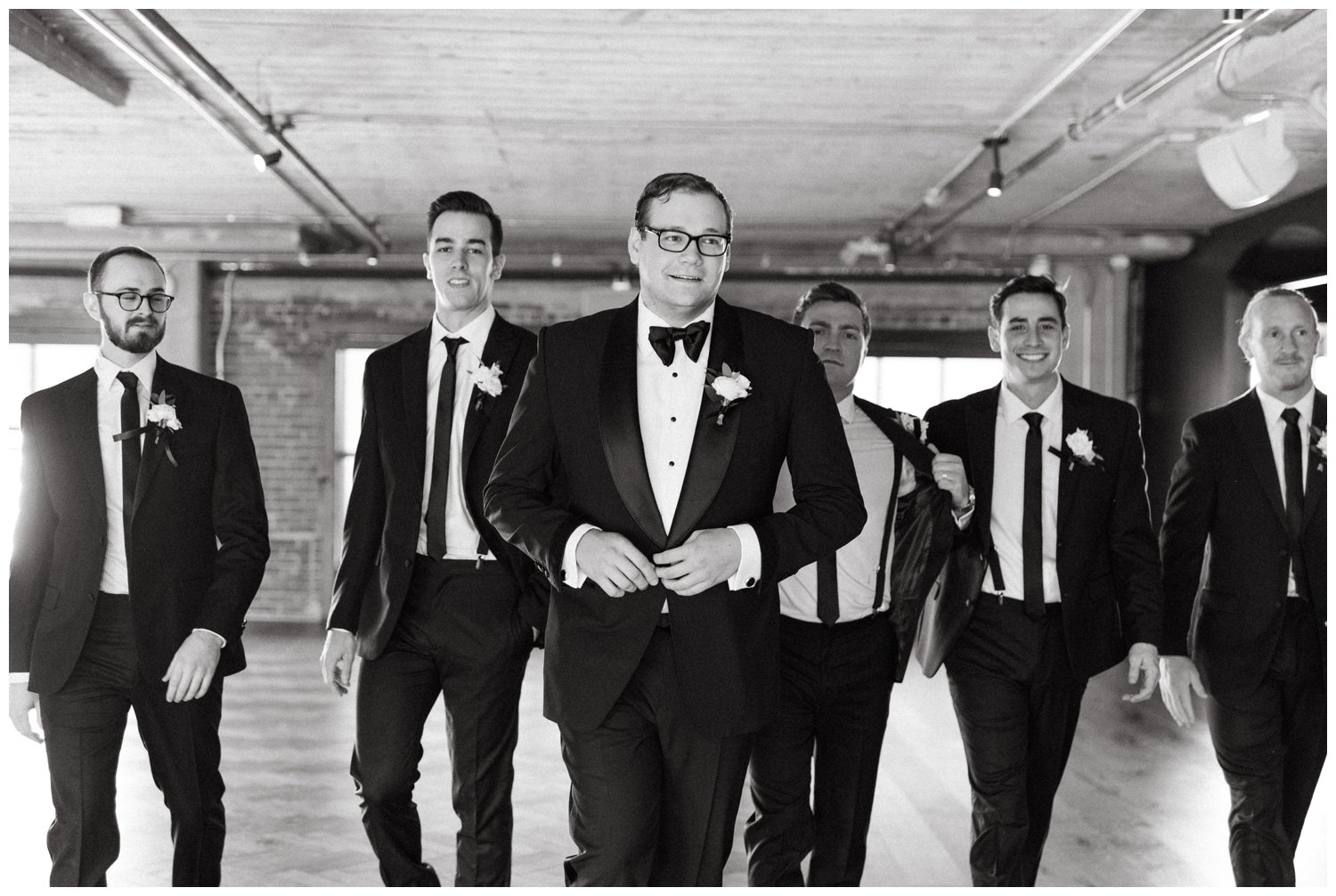 The groom walks with the groomsmen at Ponce City Market