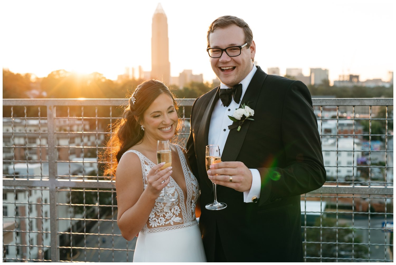 A couple drinks champagne during their small wedding reception at sunset
