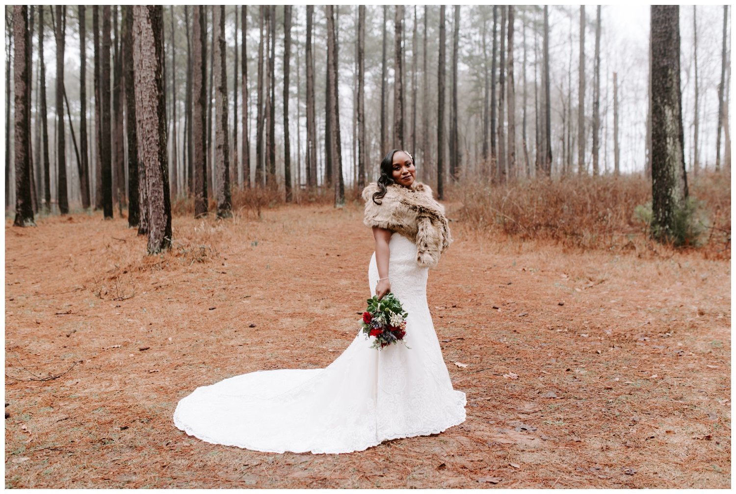 A bride wears a fur stole in the woods