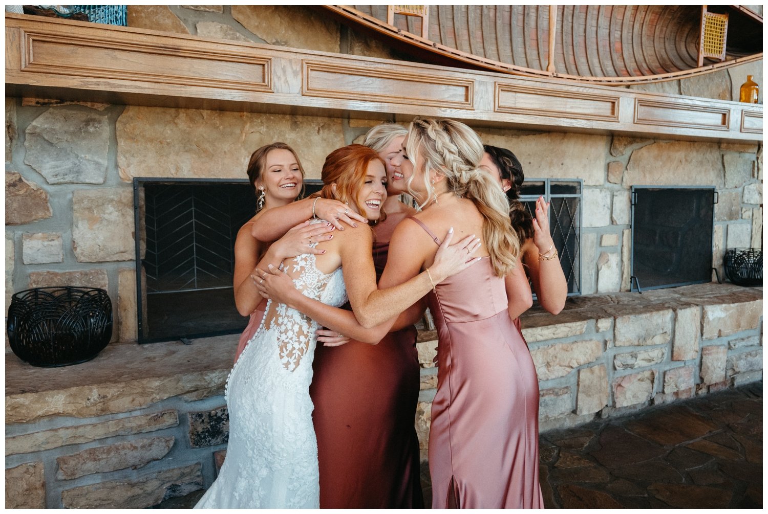 The bride and bridesmaids hug at the mountain wedding venue